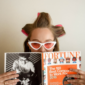 woman in curlers and sunglasses reading Fortune magazine